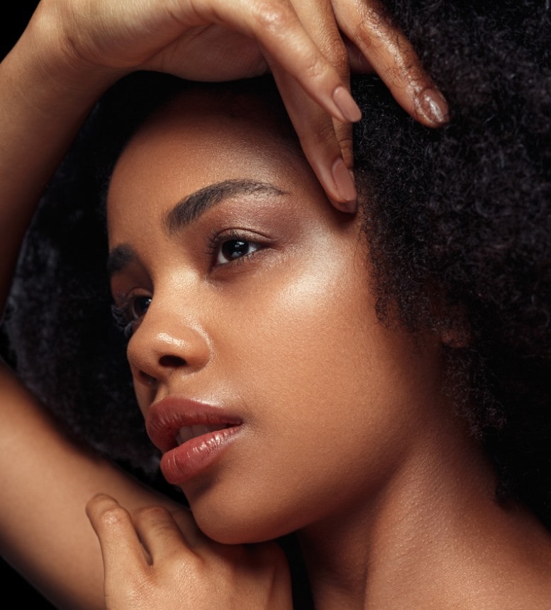 Close up portrait of gorgeous black young beautiful woman with perfect glowing skin and minimal nude makeup. RF Microneedling, Aviva Med Spa Centennial CO.